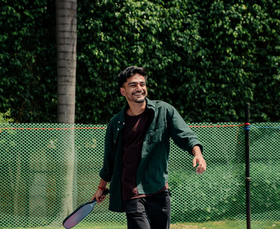 Pickleball player walking on an outdoor court with a paddle